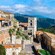 A historical Italian hamlet with stone paths, tile roofs and cast iron street lamps overlooking a valley